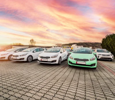 Image of selection of cars in a car park with sunset behind