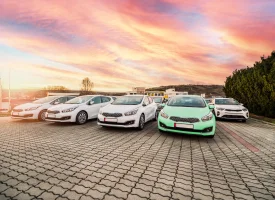 Image of selection of cars in a car park with sunset behind